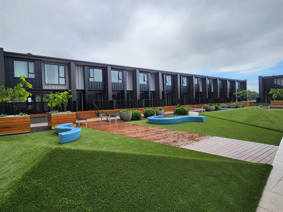 Completed ADCO Roofing Espan cladding on Hawkins townhouses beside a landscaped Tauranga CBD courtyard.