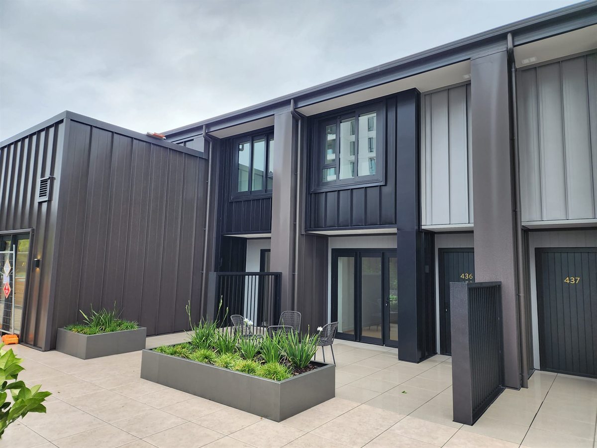 Front view of completed Tauranga CBD townhouse units with Ebony, Sandstone Grey, and Ironsand cladding.
