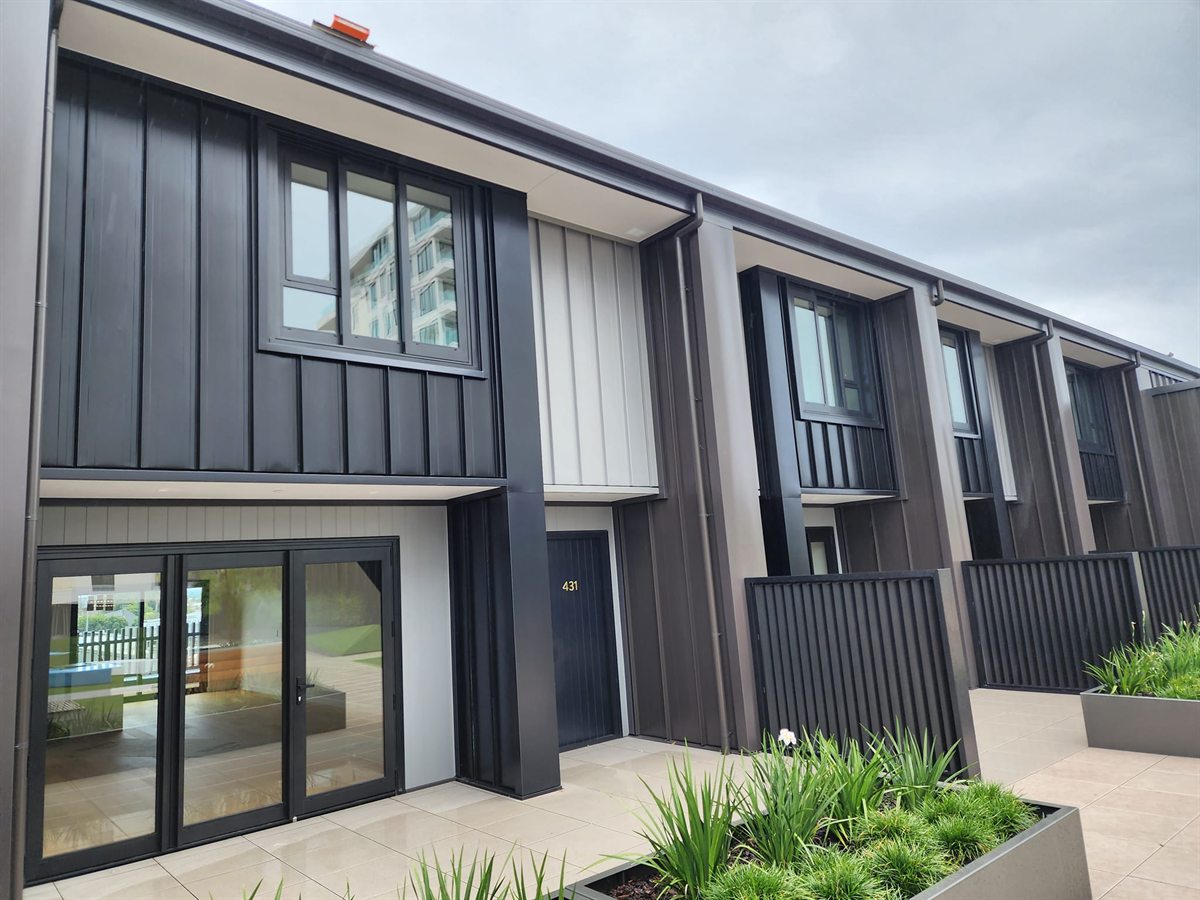 Close view of Coloursteel metal cladding and window details on completed Hawkins townhouses in Tauranga.