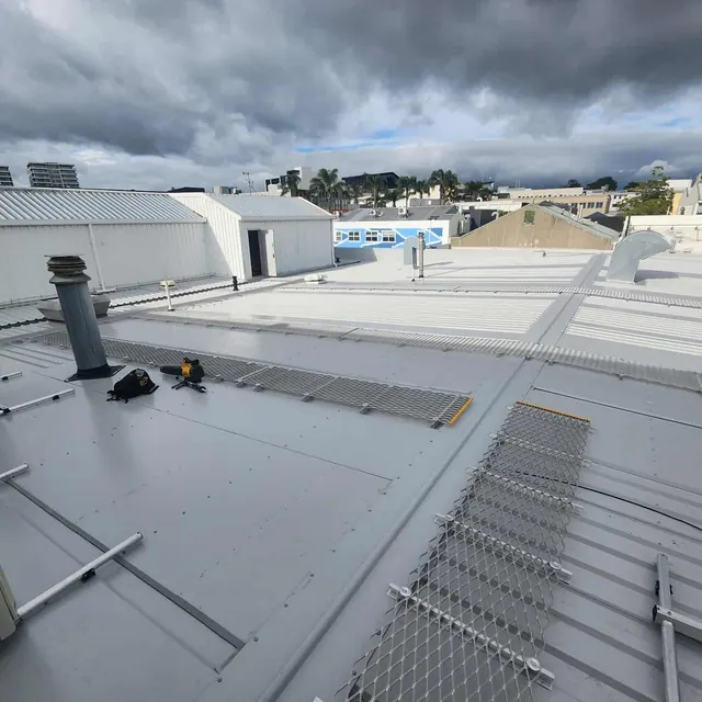 Commercial longrun roof area with internal gutters, roof mesh, and rooftop service penetrations completed by ADCO Roofing.